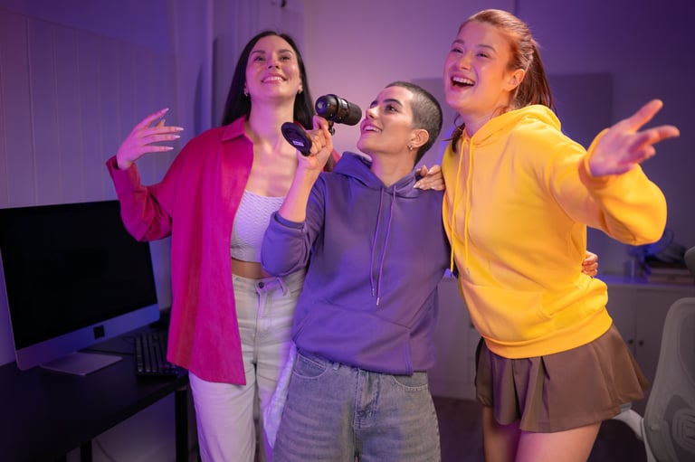 Three friends singing together into a microphone in a fun, neon-lit room. They appear energetic and joyful, enjoying a group karaoke or social entertainment activity