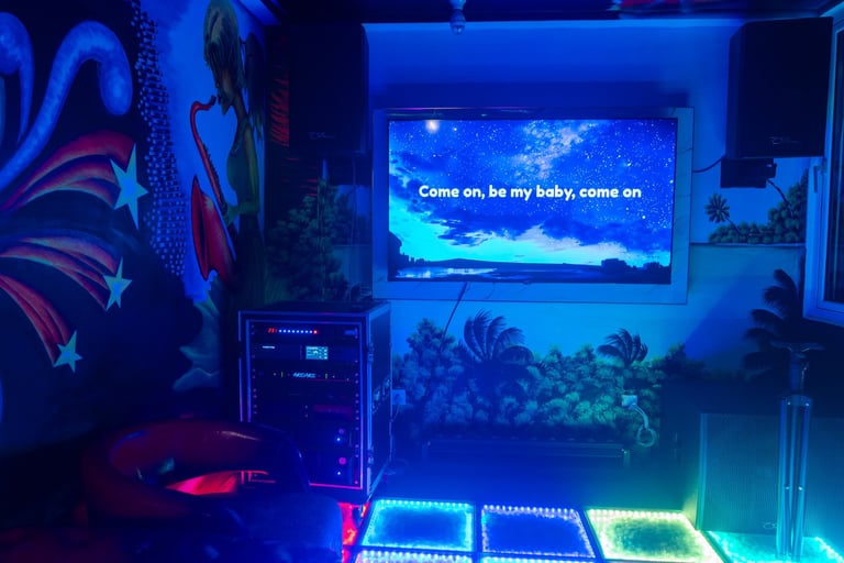 Gaming setup with neon blue and purple lighting, displaying underwater scene on monitor with text Come on, be my baby, come on