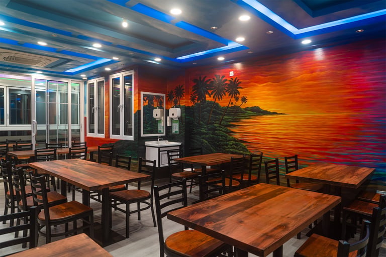 Modern restaurant interior with wooden tables and black chairs, vibrant sunset mural on accent wall, blue neon ceiling lighting, and glass doors