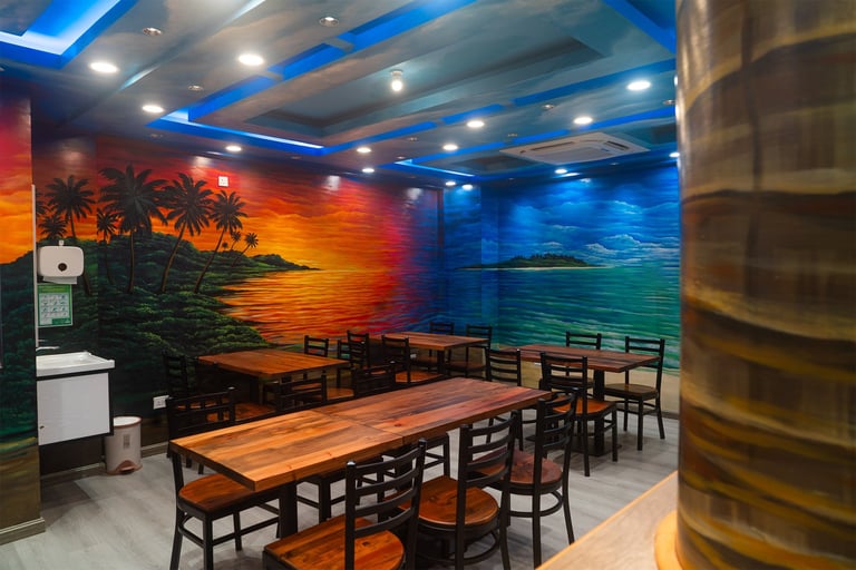 Modern restaurant interior with wooden dining tables and chairs under blue ceiling lights, tropical sunset mural on walls